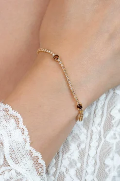 ZINZI gold plated zilveren tennisarmband 2,1mm breed bezet met champagnekleurige zirkonia’s in verfijnde rijzetting, afgewisseld met drie grotere donkerbruine kleurstenen (4,3mm) in chatonzetting ZIA2894C