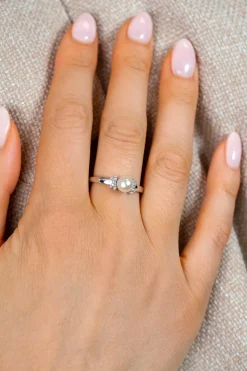 ZINZI zilveren ring met een witte parel (6mm), aan weerszijden subtiel bezet met witte zirkonia's in een strikvormige zetting ZIR2863