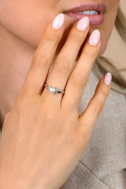 ZINZI zilveren ring met een witte parel (6mm), aan weerszijden subtiel bezet met witte zirkonia's in een strikvormige zetting ZIR2863