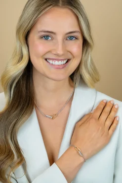 ZINZI zilveren schakelarmband met twee verbonden ovale schakels: ene gold plated, ander bezet met witte zirkonia's ZIA2758